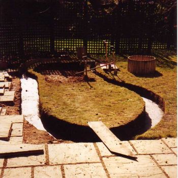 The trench has been partially filled with 10cm depth of concrete. This forms a hard edge to stop erosion when clambering in and out and forms a foundation for the dry stone wall camouflaging the vertical section of pond liner.